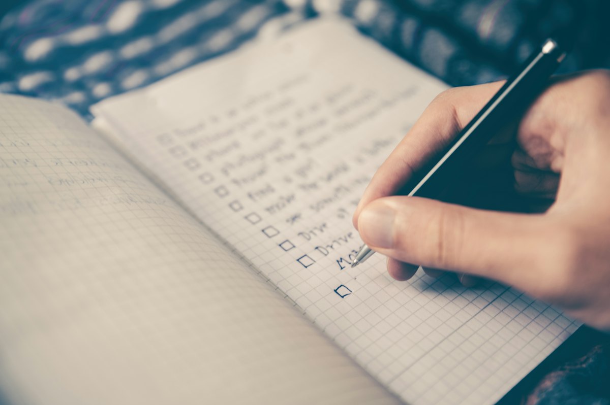 Open planner with handwritten goals beside a pen
